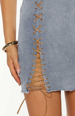 Close up of a light wash denim strapless dress with brown lacing detail a perfect bold Summer Festival look