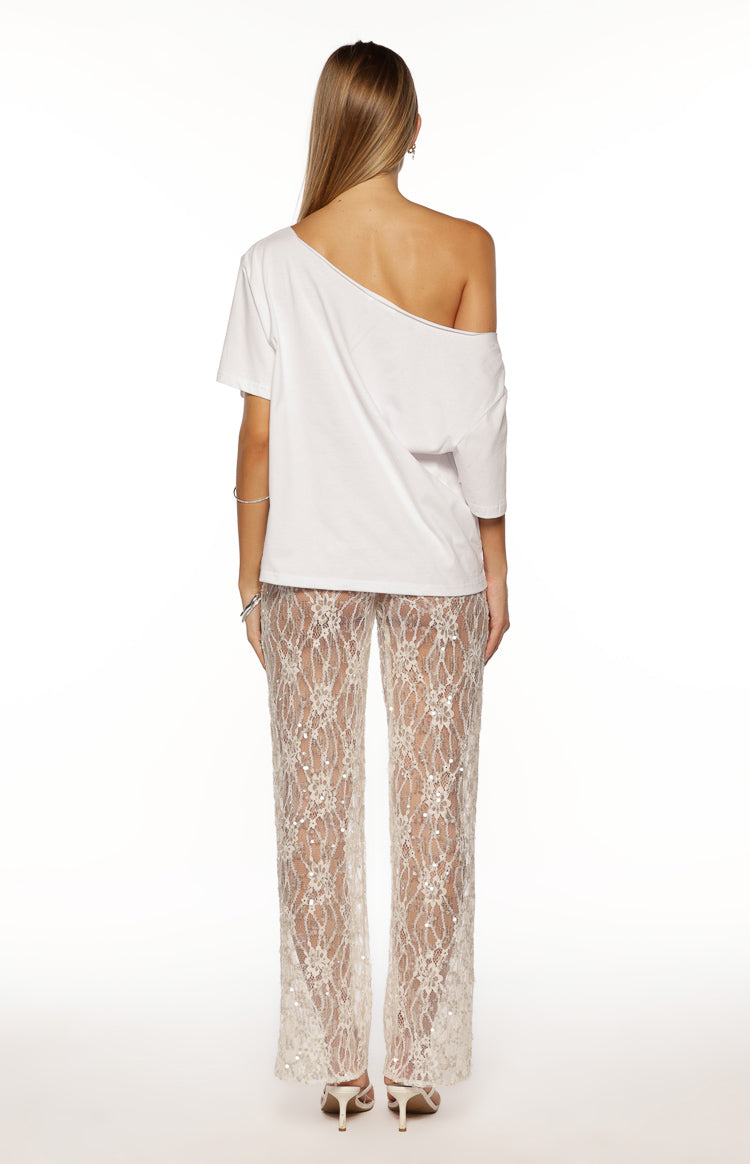 Rear view of white sheer wide-leg lace pants with intricate floral pattern and scattered sequins