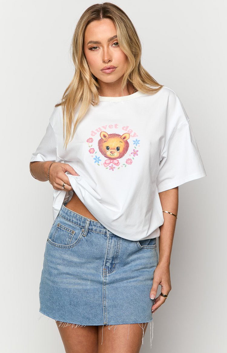 Relaxed fit white crew neck tee with a playful cartoon lion graphic, pink bow, and 'duvet day' text