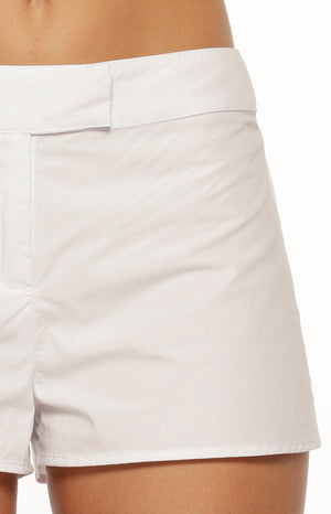 Our model highlights a pair of fitted short white shorts. These shorts have a tailored look with a flat front waistband and a visible fly/seam detail at the center.