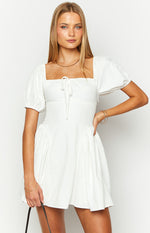 White mini dress with a square neckline, front bust tie, and short puff sleeves