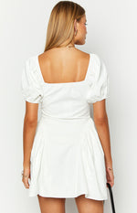 Rear view of a white mini dress with a square back neckline, short puff sleeves, and gathered details on the skirt