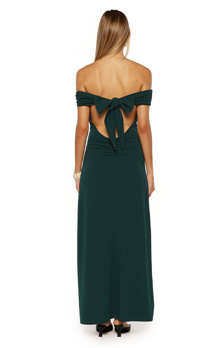 Back view of the teal crepe off-the-shoulder maxi dress with a large bow tie, open back cutout, and ruched lower back