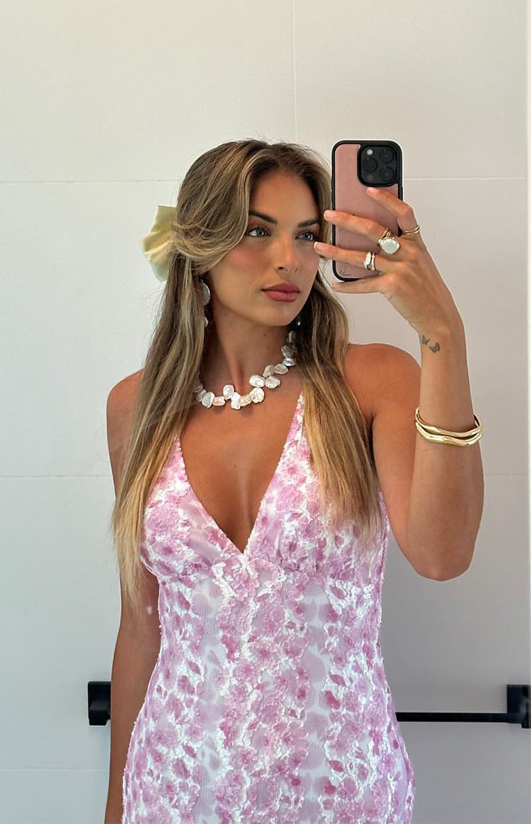 Close-up of the V-neckline and pink floral lace pattern of a maxi dress