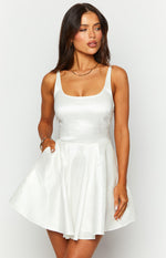 White mini dress with a square neckline, wide straps, fitted bodice, and a full flared skirt with pockets