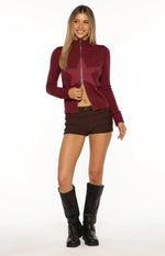 Burgundy knit sweater with a subtle knit star pattern, full zip front, high mock neck, and ribbed cuffs