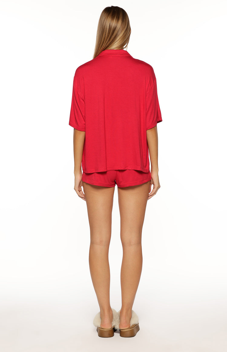 Rear view of the red short sleeve collared pajama top and matching mini pajama shorts