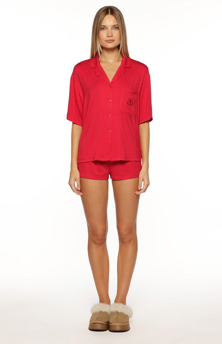 Burgundy short sleeve pajama shirt with collared V-neck, button-front, and chest pocket with embroidered logo