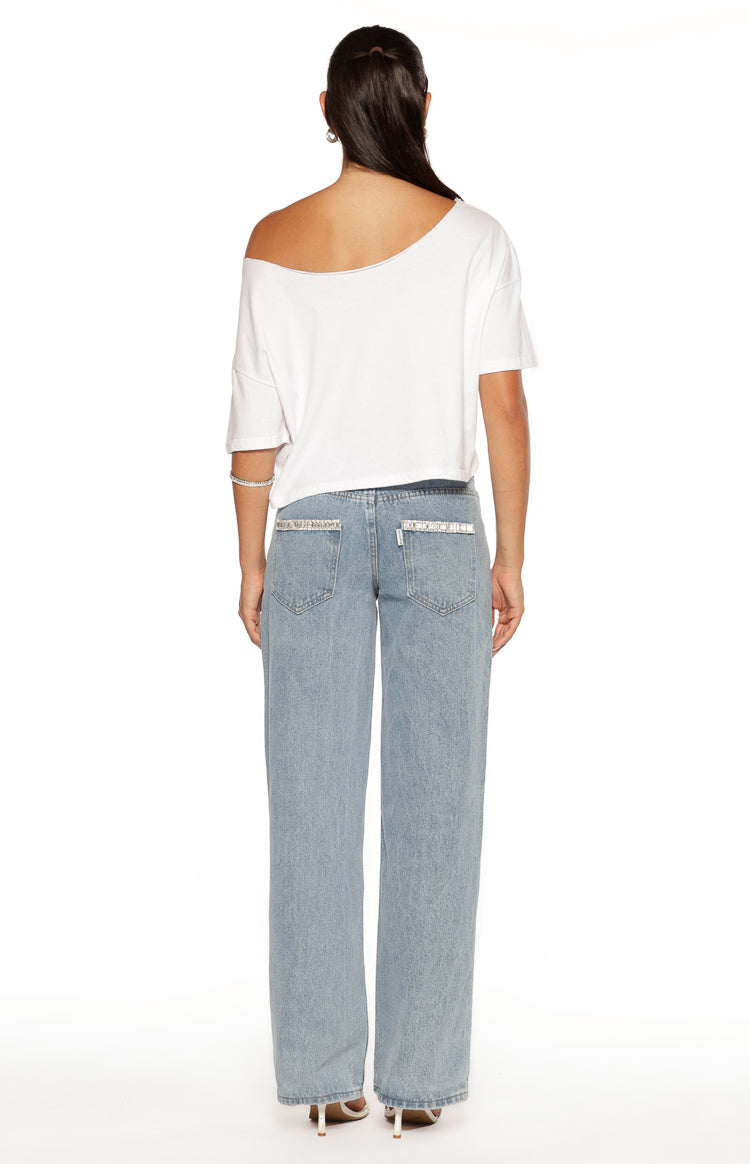 Rear view of light wash denim jeans with diamante trim on the back pockets and waistband