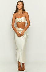 Full length front view of a champagne strapless crop top with ruched texture and a satin rose detail