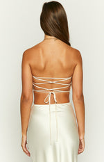 Rear view of a champagne satin crop top showing the thin criss-cross tie-back straps and self-tie closure