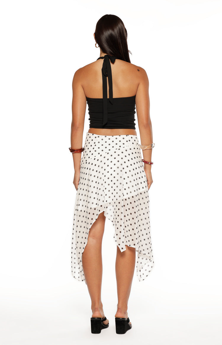 Rear view of a white polka dot hanky hem midi skirt showing the uneven pointed hemline