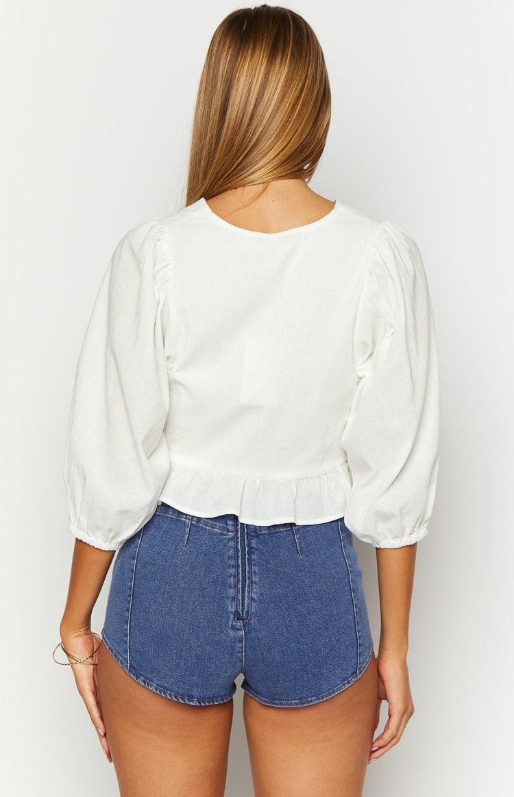 Rear view of dark denim micro shorts with a visible back zipper and curved hemline