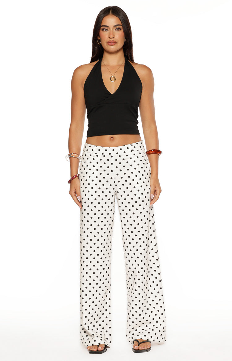 Front view of white low waist pants with black polka dots, featuring a relaxed wide-leg fit