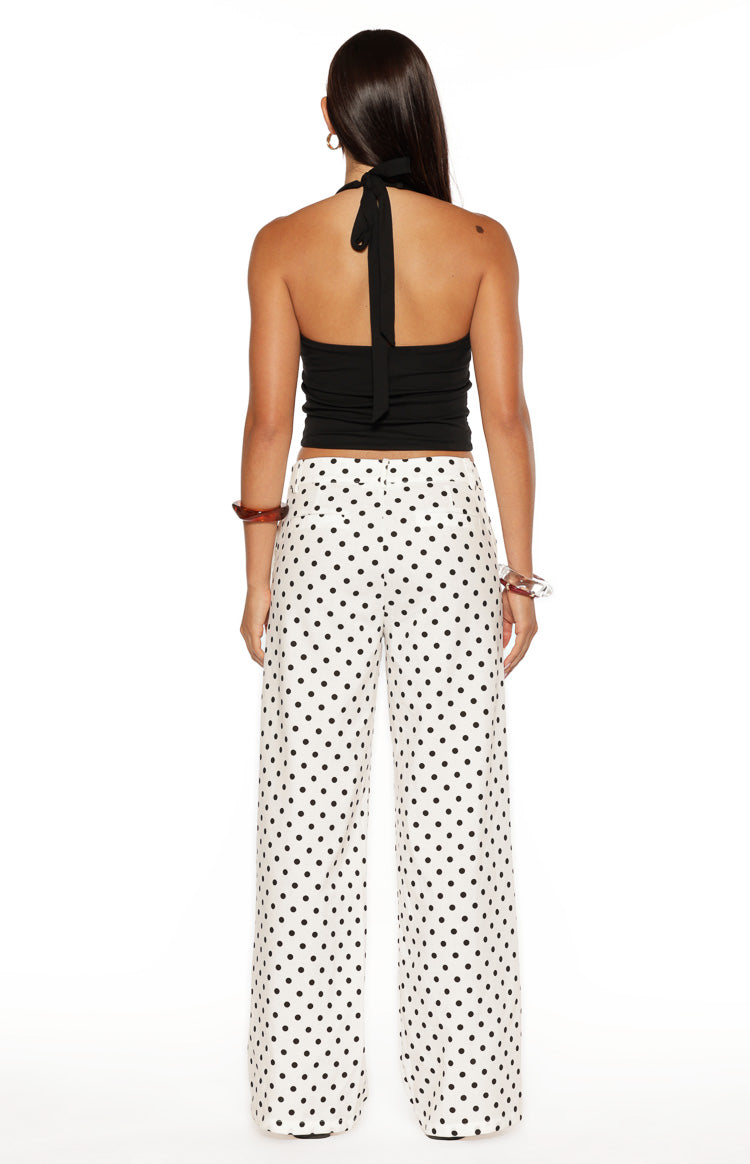 Rear view of white wide-leg pants with black polka dots and a low waist