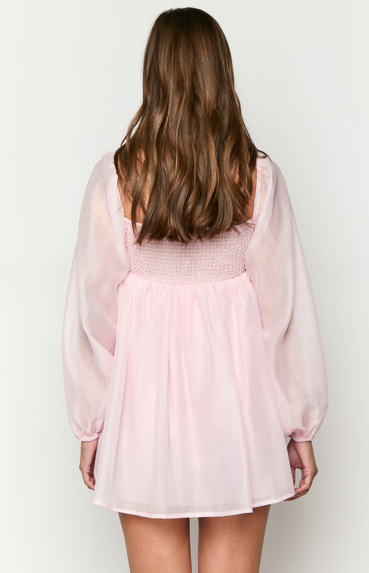 Rear view of the pink mini dress showing the shirred back bodice, square neckline, and sheer long sleeves