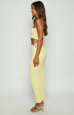 Side view of a yellow ribbed knit strapless tube top with white contrast binding and a cropped fit