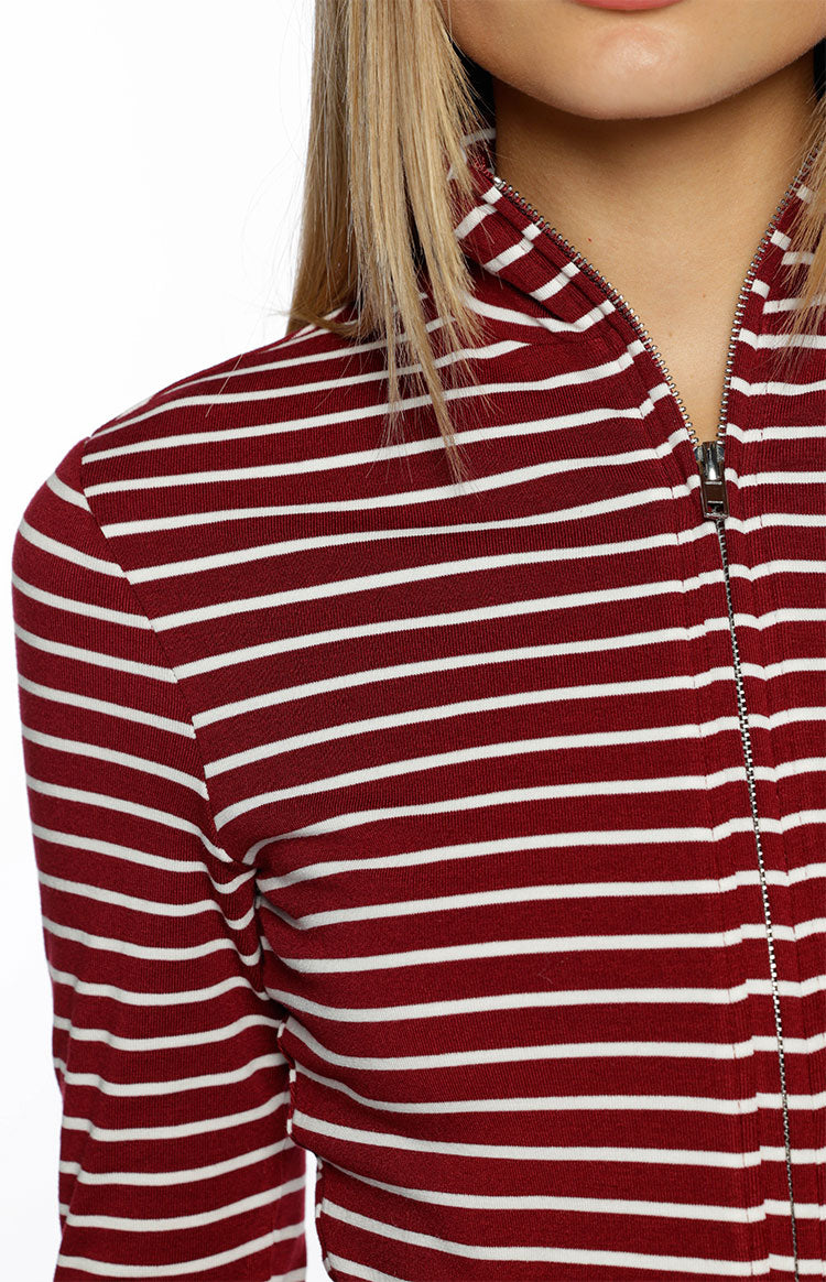 Close-up of the burgundy and white striped sweater with a silver zipper detail on the high neck