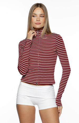 Our model is wearing a fitted long-sleeve sweater with a burgundy and thin white horizontal stripe pattern. This top features a high mock-neck collar and a full-length silver zipper down the front.