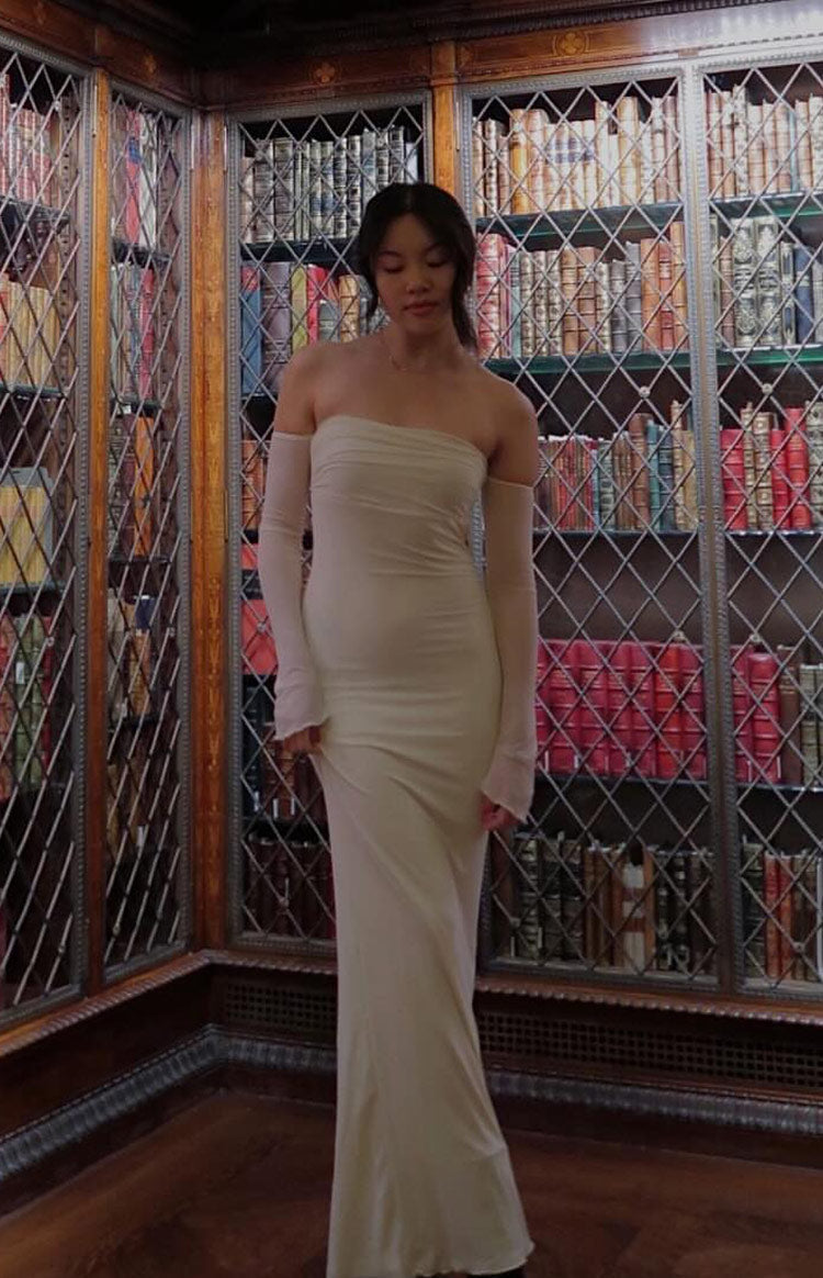 Side view of a cream strapless maxi dress with long sheer detached sleeves