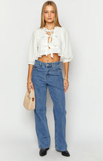 White tie up top with a V-neck, multiple front ties, half puff sleeves, and a ruffled cropped hem