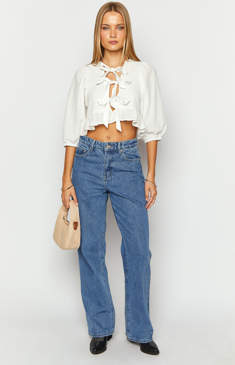 White tie up top with a V-neck, multiple front ties, half puff sleeves, and a ruffled cropped hem