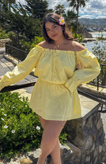 Yellow Bardot mini dress with a ruffled off-shoulder neckline, front tie detail, long billowy sleeves, and elasticated waist