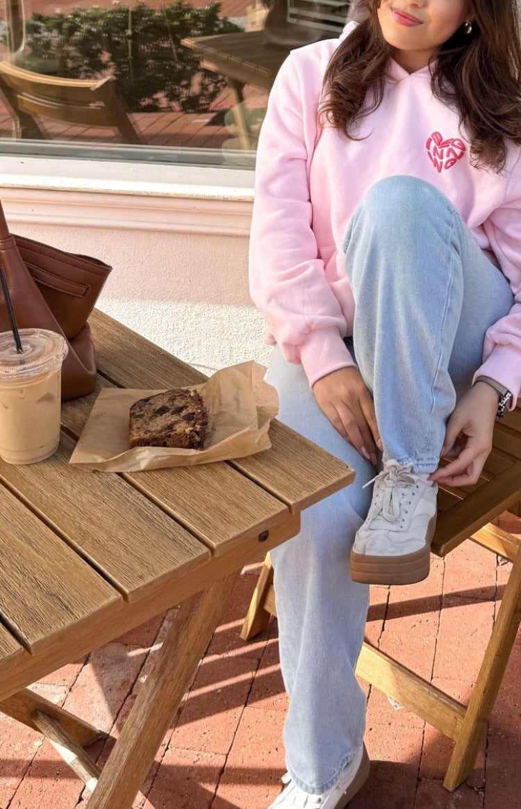 Pink oversized hoodie with a red heart graphic on the chest, long sleeves, and ribbed cuffs