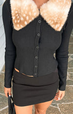 Smooth black low waisted mini skirt with a fitted silhouette and straight hem