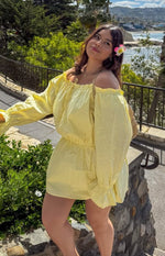 Yellow Bardot mini dress with off-shoulder ruffled neckline, long puff sleeves, elasticated waist, and flowy skirt