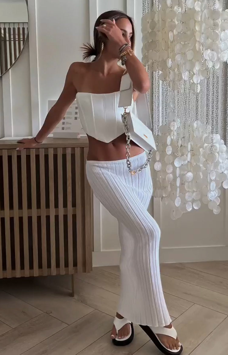 White ribbed knit maxi skirt with a fitted silhouette and slight flare at the hem