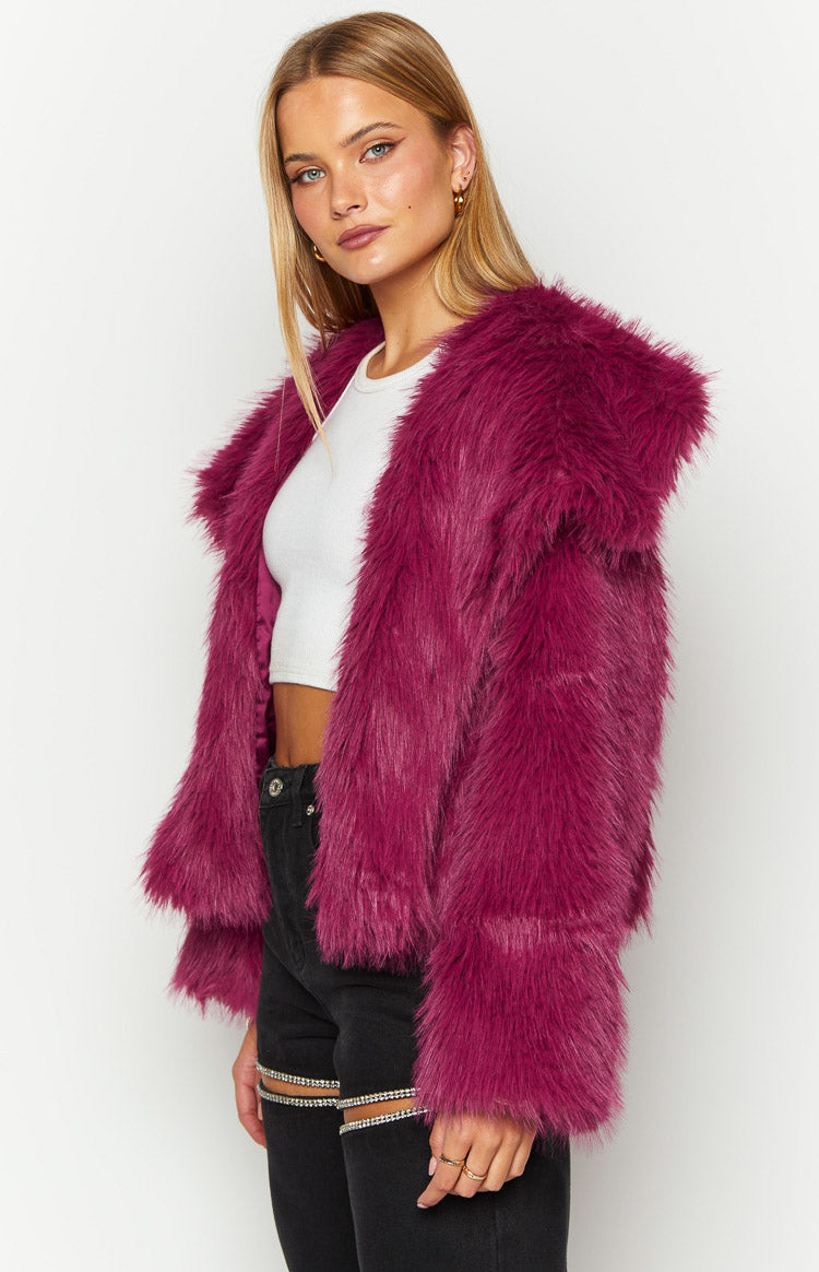 Side view of the purple faux fur jacket, highlighting its shaggy texture, wide lapel, and magenta satin lining