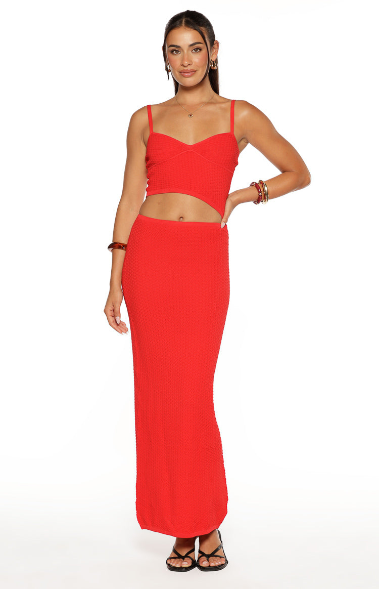 Front view of a red textured knit maxi dress featuring a sweetheart neckline, thin straps, and midriff cutout