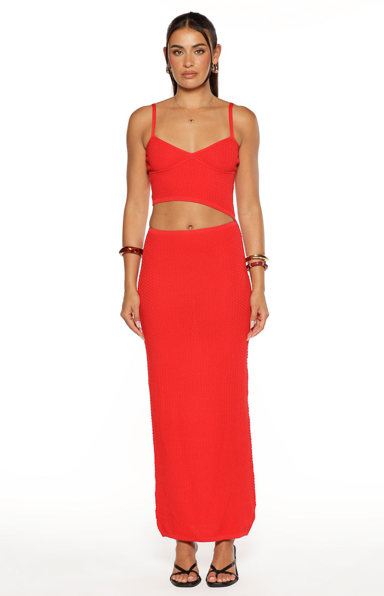 Front view of a red knit maxi dress with a sweetheart neckline, spaghetti straps, and a side waist cut out