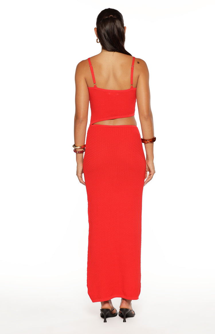 Back view of the red knit maxi dress showing adjustable straps and a diagonal waist cutout