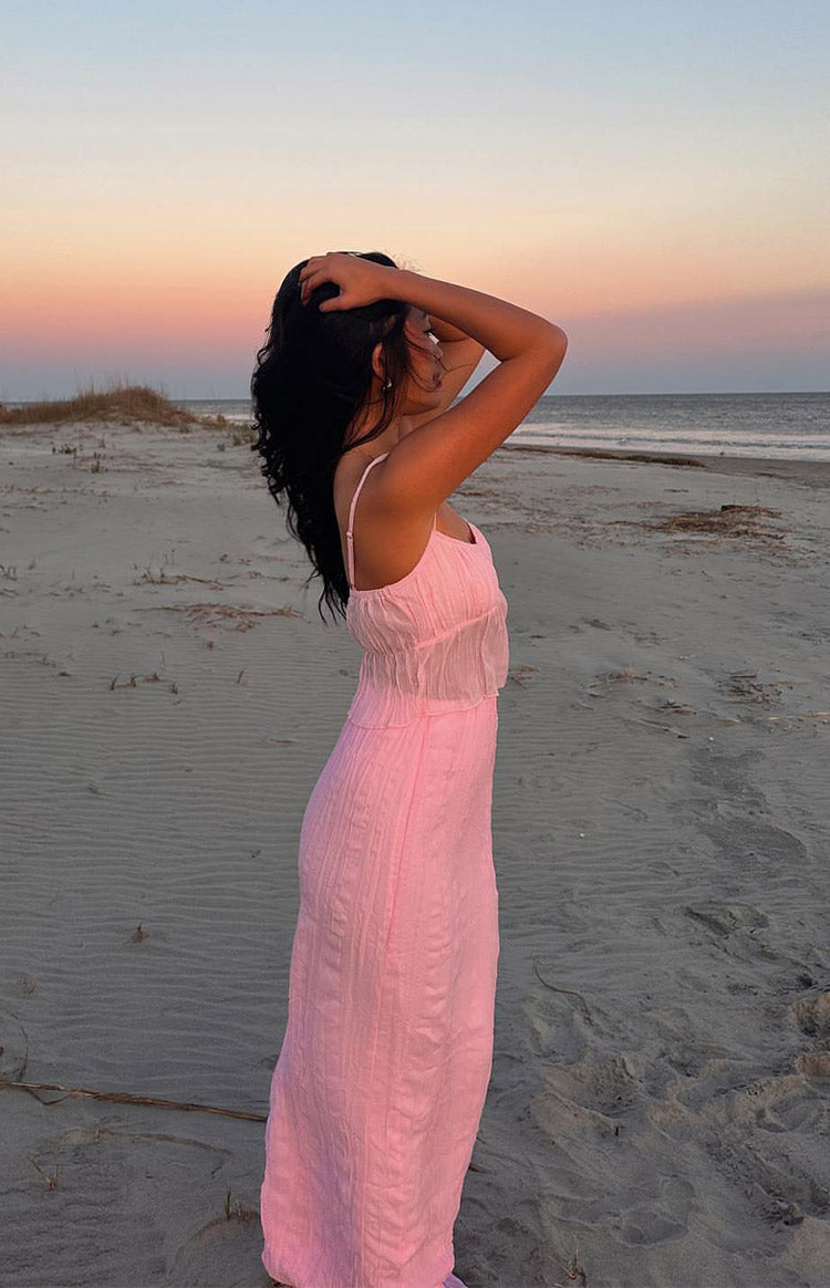 Side view of a pink cami top with thin spaghetti straps, ruched bodice, and sheer overlay