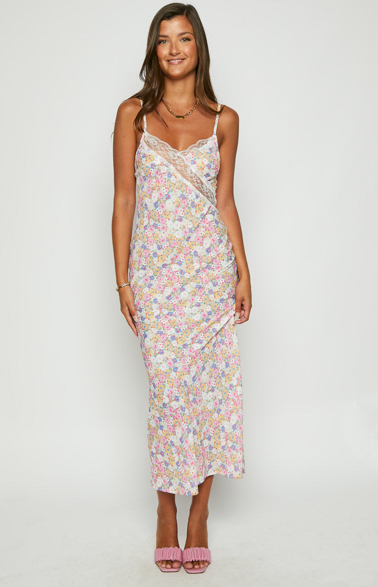 Front view of a white floral maxi dress with a V-neckline and diagonal lace trim across the bust
