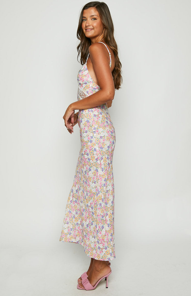 Side view of a white floral lace maxi dress showing the lace cutout detail on the bodice and flowy skirt