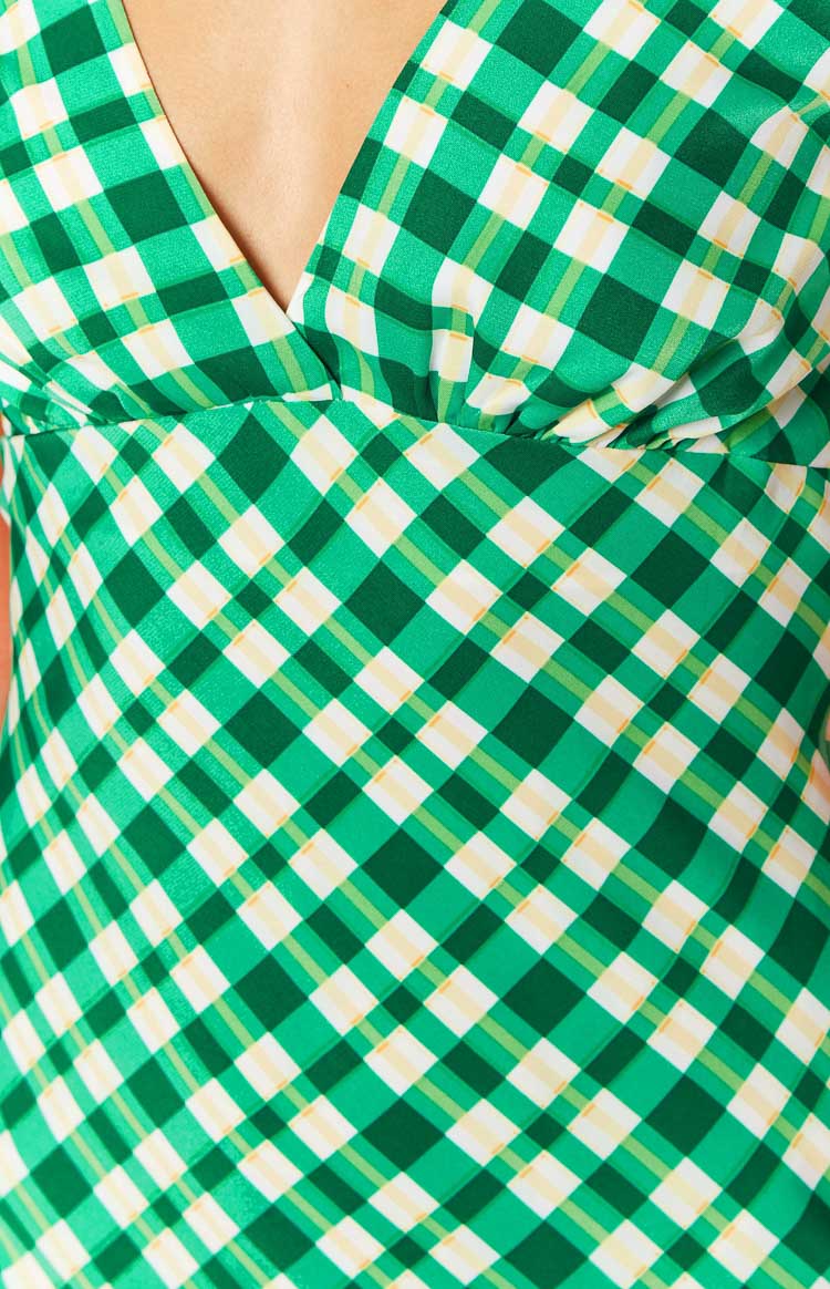 Close-up of the green, white, and yellow check pattern on the gathered bust and V-neckline of a maxi dress