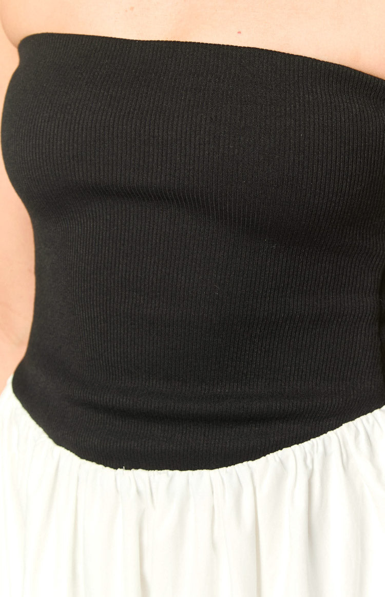 Detail shot of the black ribbed knit strapless bodice and the gathered white skirt