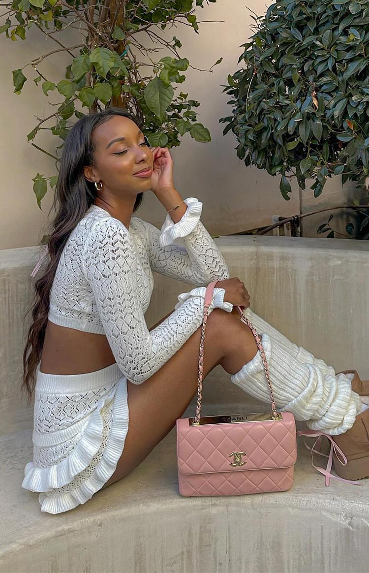 White knit shorts with an intricate openwork pattern and double-tiered ruffles along the leg openings