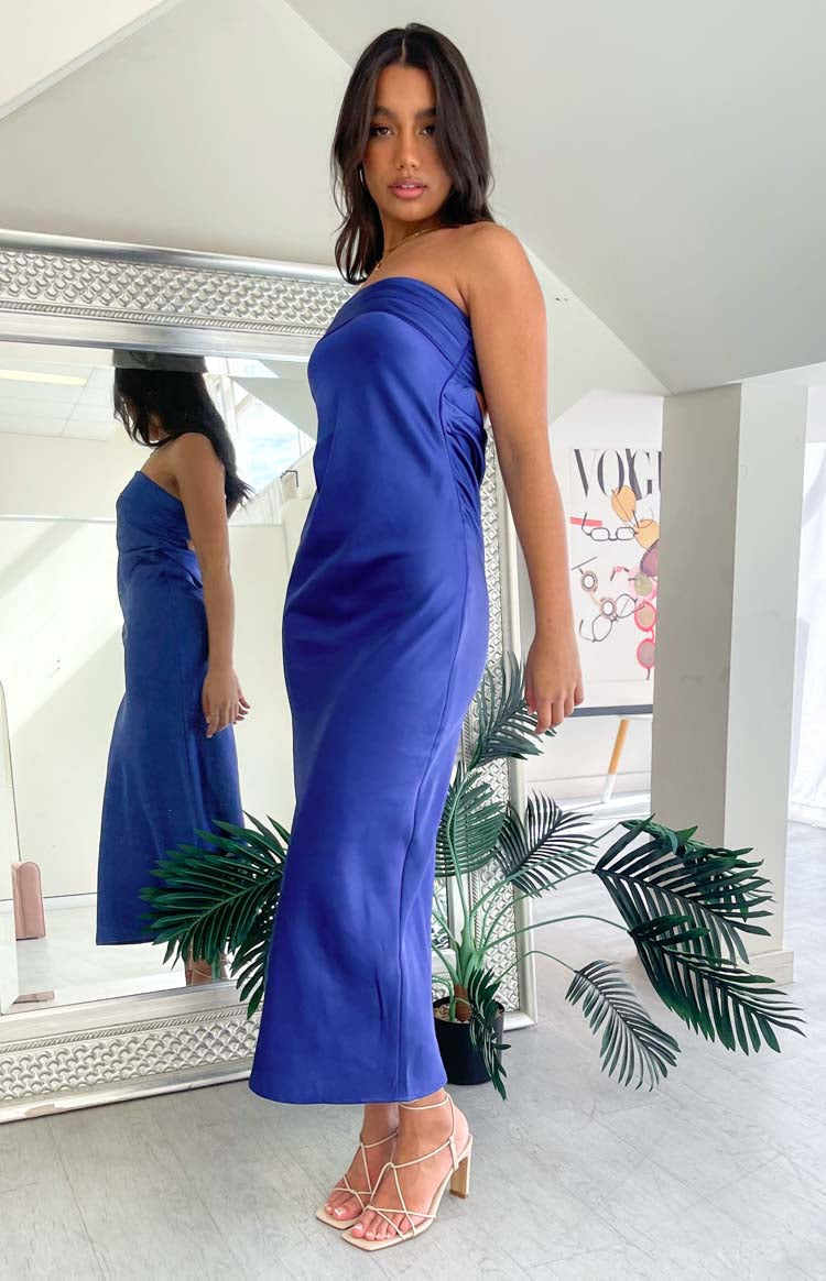Side view of a navy strapless maxi dress showing the draped neckline and fitted silhouette
